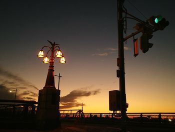 Low angle view of illuminated street light against sky