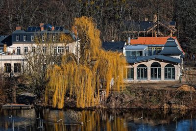 House by lake against buildings