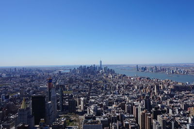 Aerial view of cityscape against blue sky