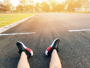 Low section of woman sitting on road