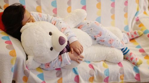 Close-up of cute girl sleeping with toy at home