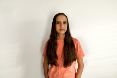 Portrait of girl standing against wall