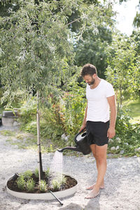 Man watering plants in garden, stockholm, sweden
