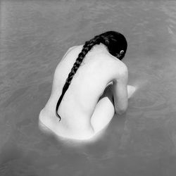 Rear view of shirtless man in swimming pool