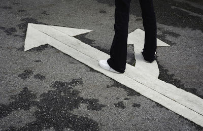 Low section of man walking on road