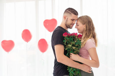 Young couple standing on heart shape at home