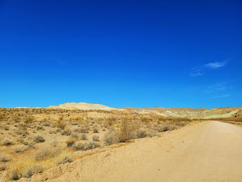 Scenic view of arid landscape against clear blue sky
