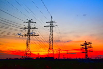 Silhouette electricity pylon against sky during sunset