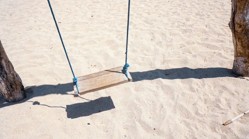 Low section of person standing on swing in playground