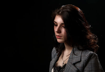 Portrait of a beautiful young woman over black background