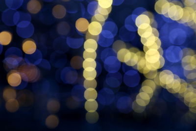 Defocused image of illuminated christmas lights at night