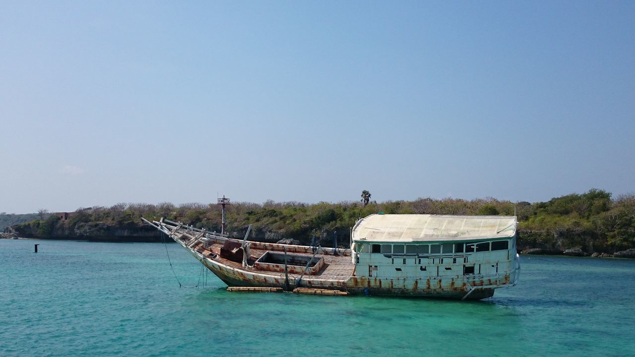 water, clear sky, transportation, waterfront, copy space, nautical vessel, built structure, boat, mode of transport, architecture, blue, sea, river, tranquility, tranquil scene, nature, lake, day, moored, outdoors