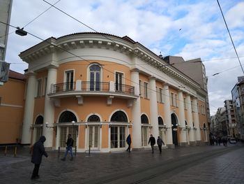 People walking on street amidst buildings in city