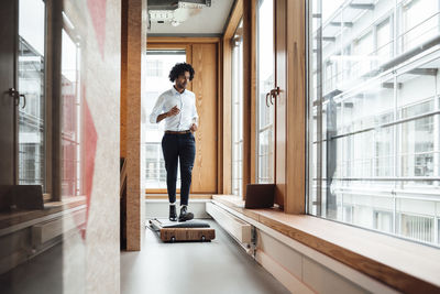 Side view of man looking through window