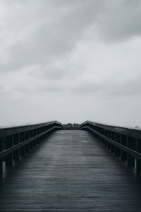 Footbridge over pier against sky