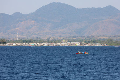 Scenic view of sea and mountains against sky