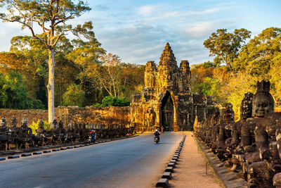 Motorbikes on the bridge leading to south gate of angkor thom, cambodia