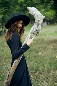 Full length of woman wearing hat standing on field