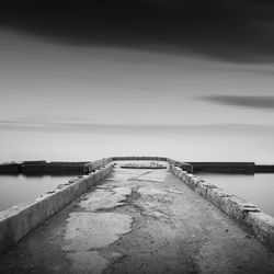 Pier amidst sea against cloudy sky