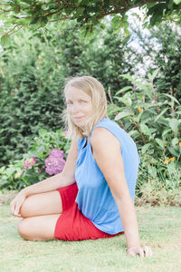 Portrait of smiling woman sitting on field