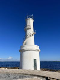 Low angle view of lighthouse against clear blue sky