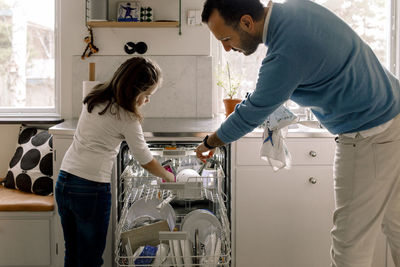 Rear view of mother with daughter standing at home