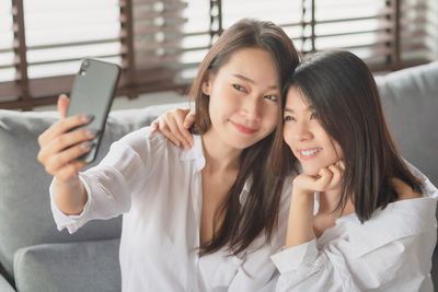 Young woman using mobile phone in laptop