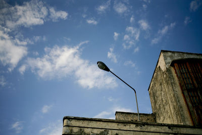 Low angle view of seagull perching on building against sky