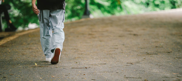 Low section of man walking on footpath