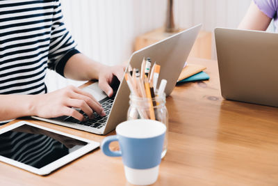 Midsection of man using laptop on table