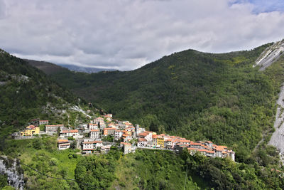 Scenic view of townscape by mountains against sky