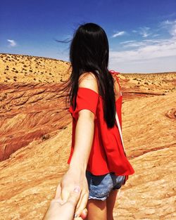 Cropped hand of man holding young woman on mountain at antelope canyon