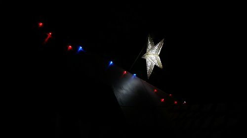 Low angle view of illuminated christmas lights at night