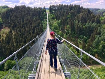 Rear view of woman standing on footbridge