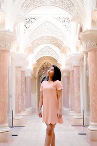 Thoughtful young woman standing in arcade