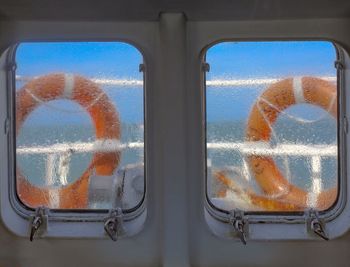 Close-up of glass window against orange sky
