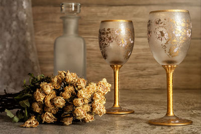 Still life of two empty glass of wine with wine bottle and dry flowers bouquet