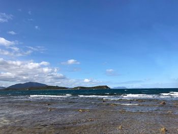 Scenic view of beach against blue sky