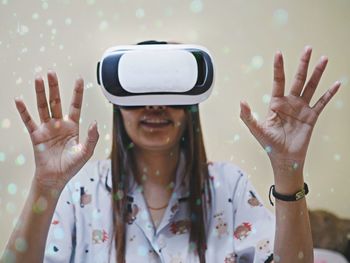 Woman gesturing while using virtual reality simulator