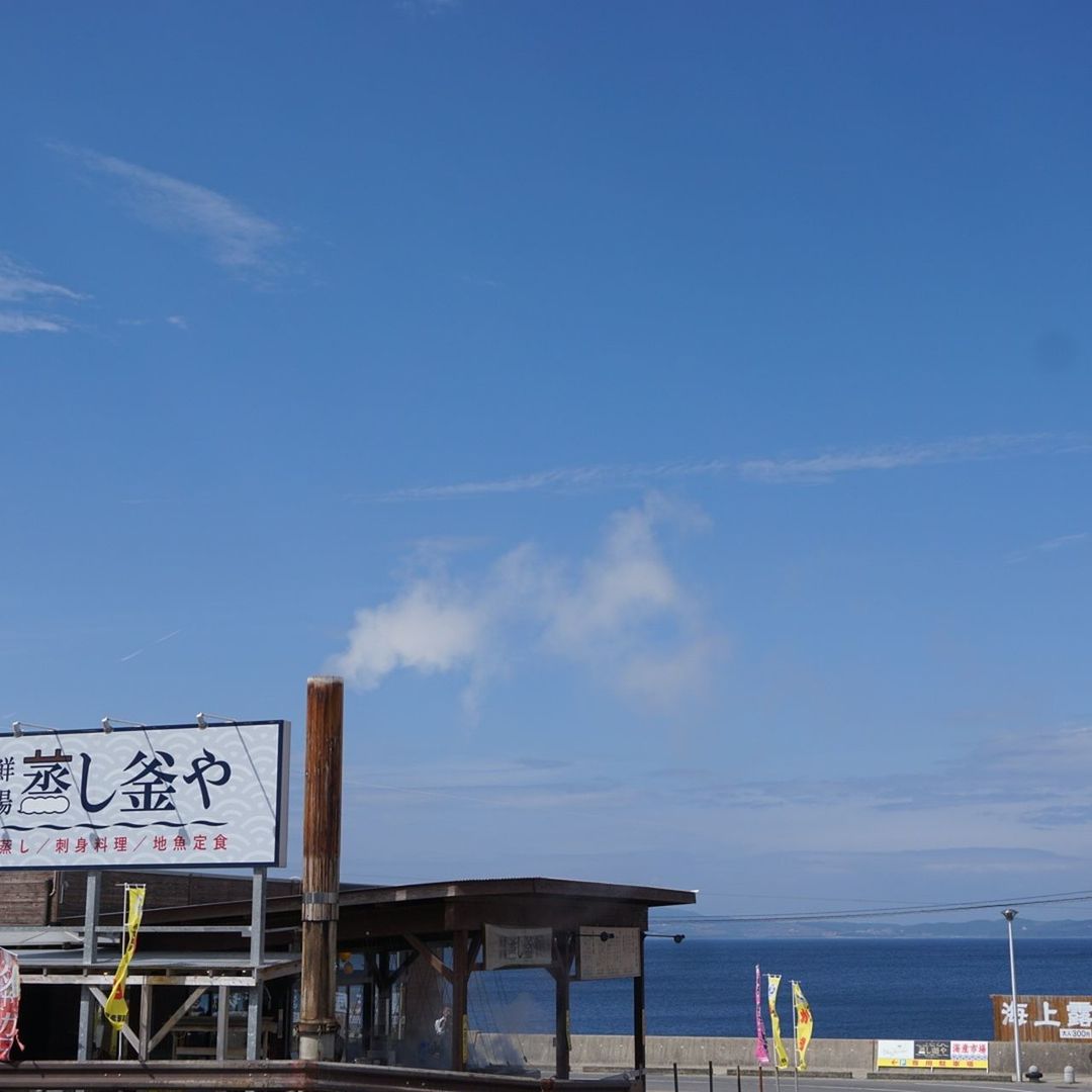 sea, sky, text, beach, horizon over water, water, blue, western script, communication, built structure, cloud - sky, railing, shore, day, transportation, incidental people, cloud, outdoors, information sign, nature
