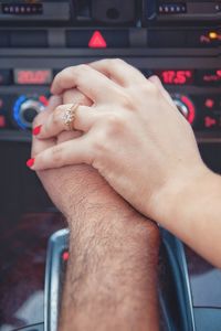 Cropped hands of couple in car