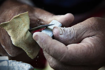 Close-up of hands carving stone