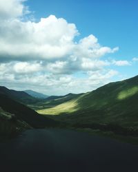 Scenic view of road amidst mountains against sky