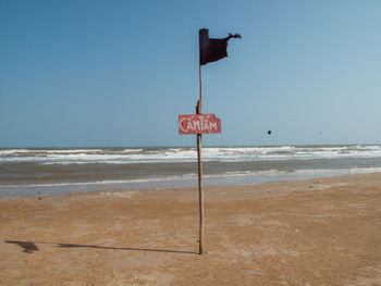 Lifeguard hut on beach against clear sky