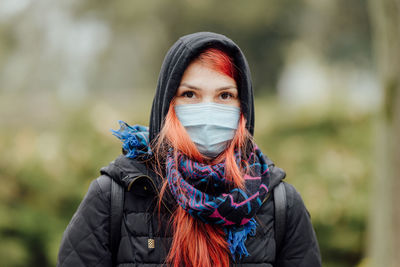 Portrait of young woman wearing mask outdoors