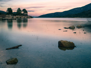 Scenic view of lake against sky at sunset