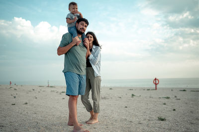 Rear view of couple standing at beach