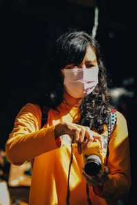 Side view of young woman photographing through camera