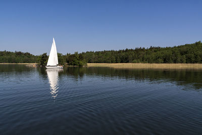 Sailboat in lake against sky