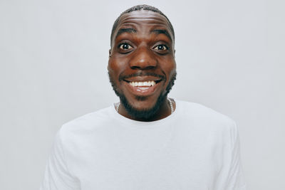 Portrait of young man standing against white background